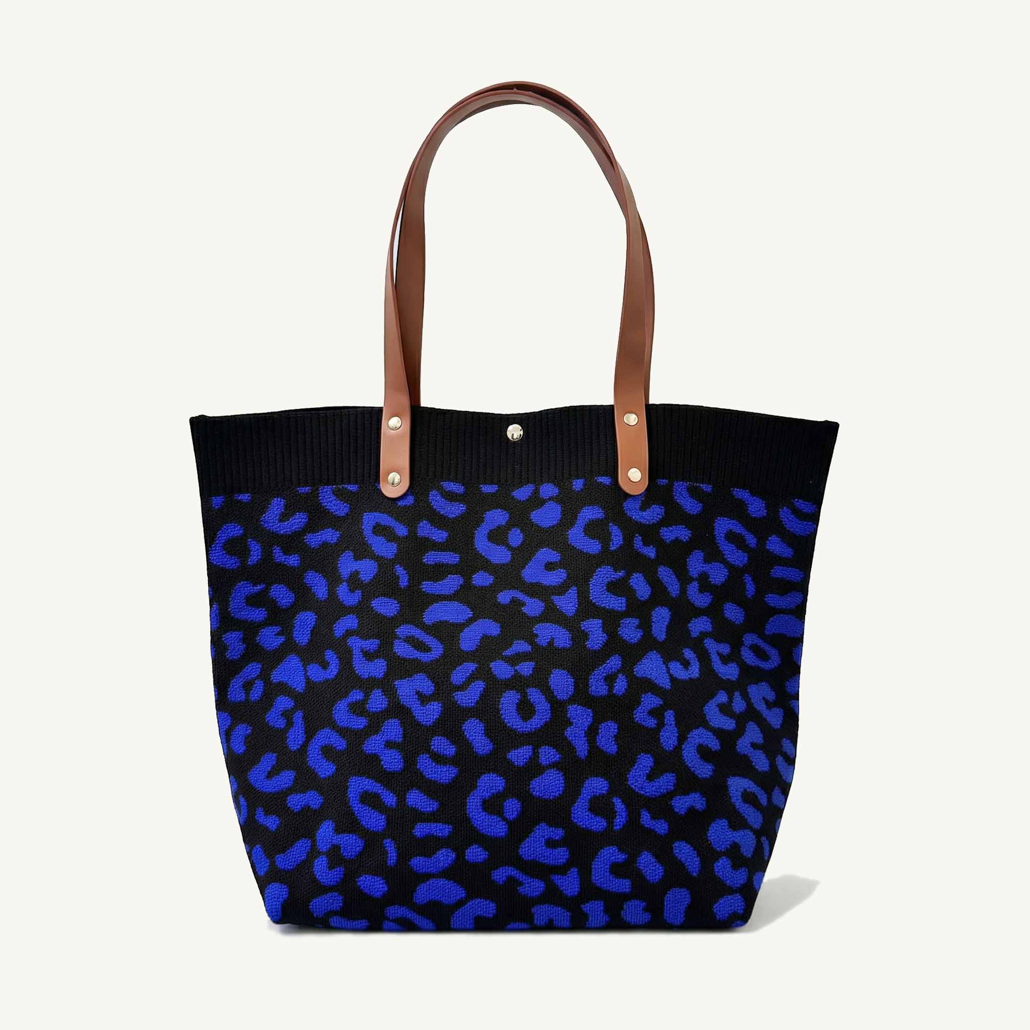 Dark blue leopard patterned knit tote bag with brown handles, front view