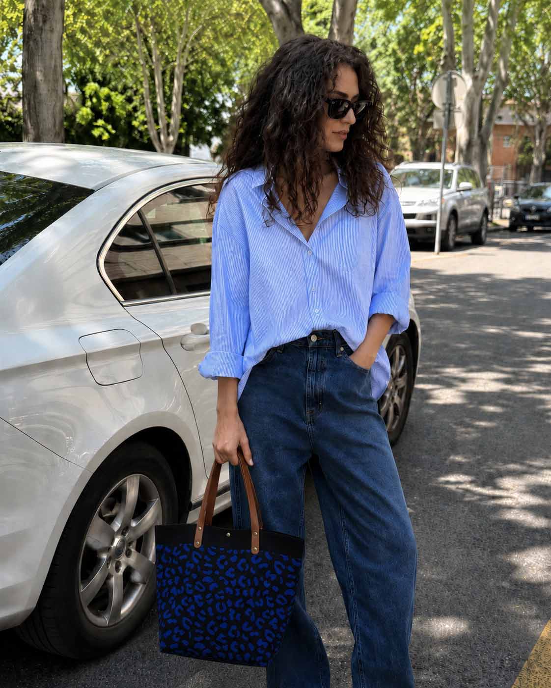 Woman carrying a dark blue leopard patterned knit tote bag