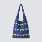 Blue slouchy knit beach bag with ivory heart patterns on a simple product background