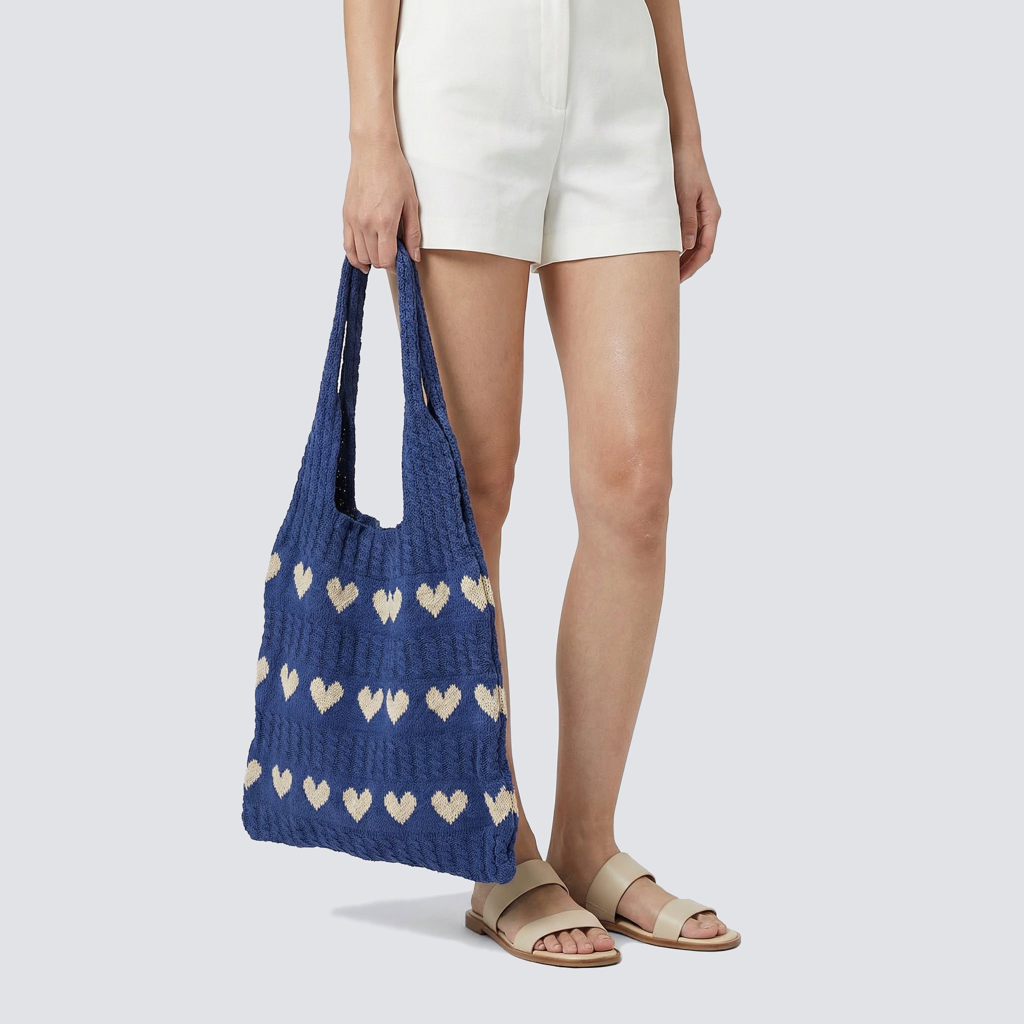 Blue slouchy knit beach bag worn over the shoulder with a casual warm-weather look