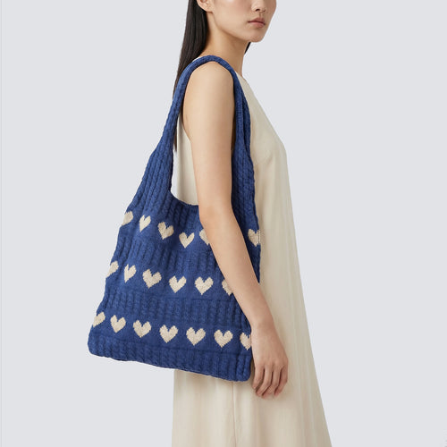 Woman styling a blue slouchy knit beach bag with a relaxed summer outfit