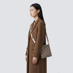 Woman wearing a brown patterned knit crossbody bag with a casual everyday outfit