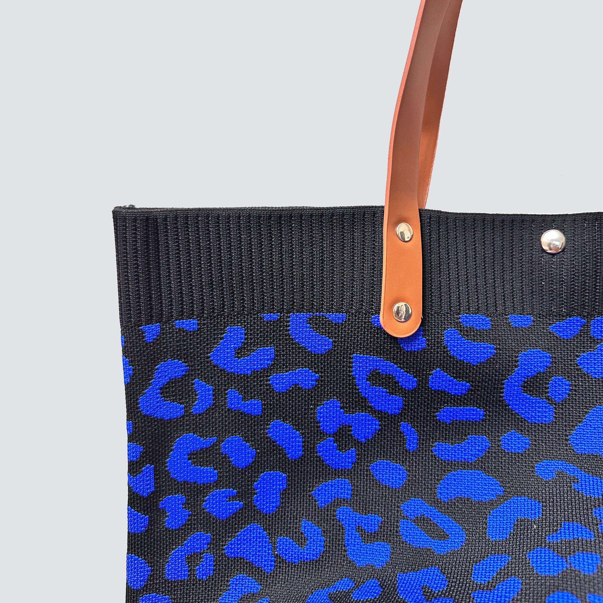 Close-up of the dark blue and black patterned knit texture on a tote bag