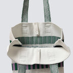Handle and grid knit texture detail of a green and white mini tote bag