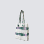 Side view of a green and white grid knit mini tote bag with double handles