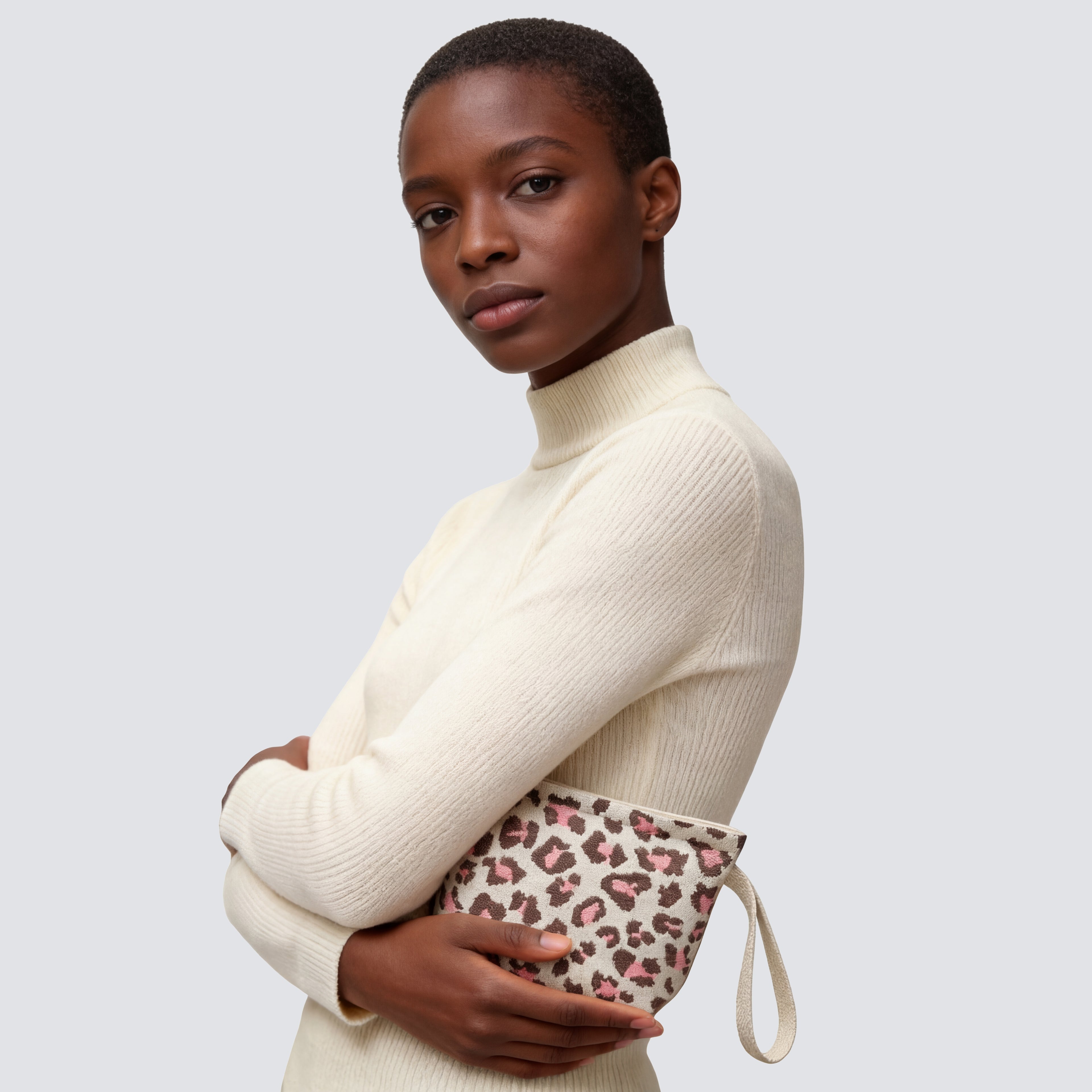 Leopard print knit mini pouch and makeup bag carried by hand