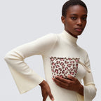 Woman carrying a leopard print knit mini pouch and makeup bag with a casual outfit