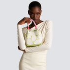 Woman carrying a light green patterned knit mini tote bag with a casual outfit