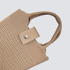 Close-up of the button closure and woven texture on a natural mini beach tote bag