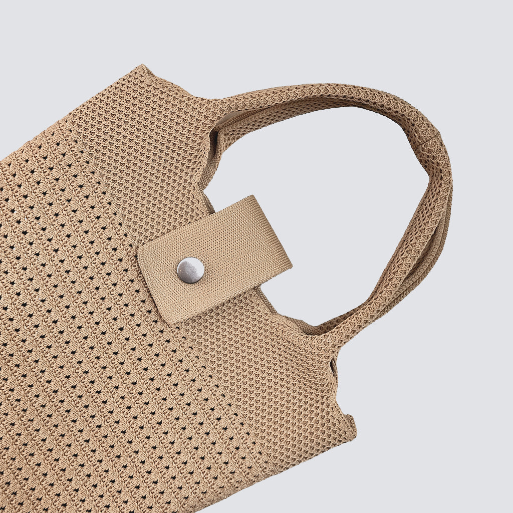 Close-up of the button closure and woven texture on a natural mini beach tote bag
