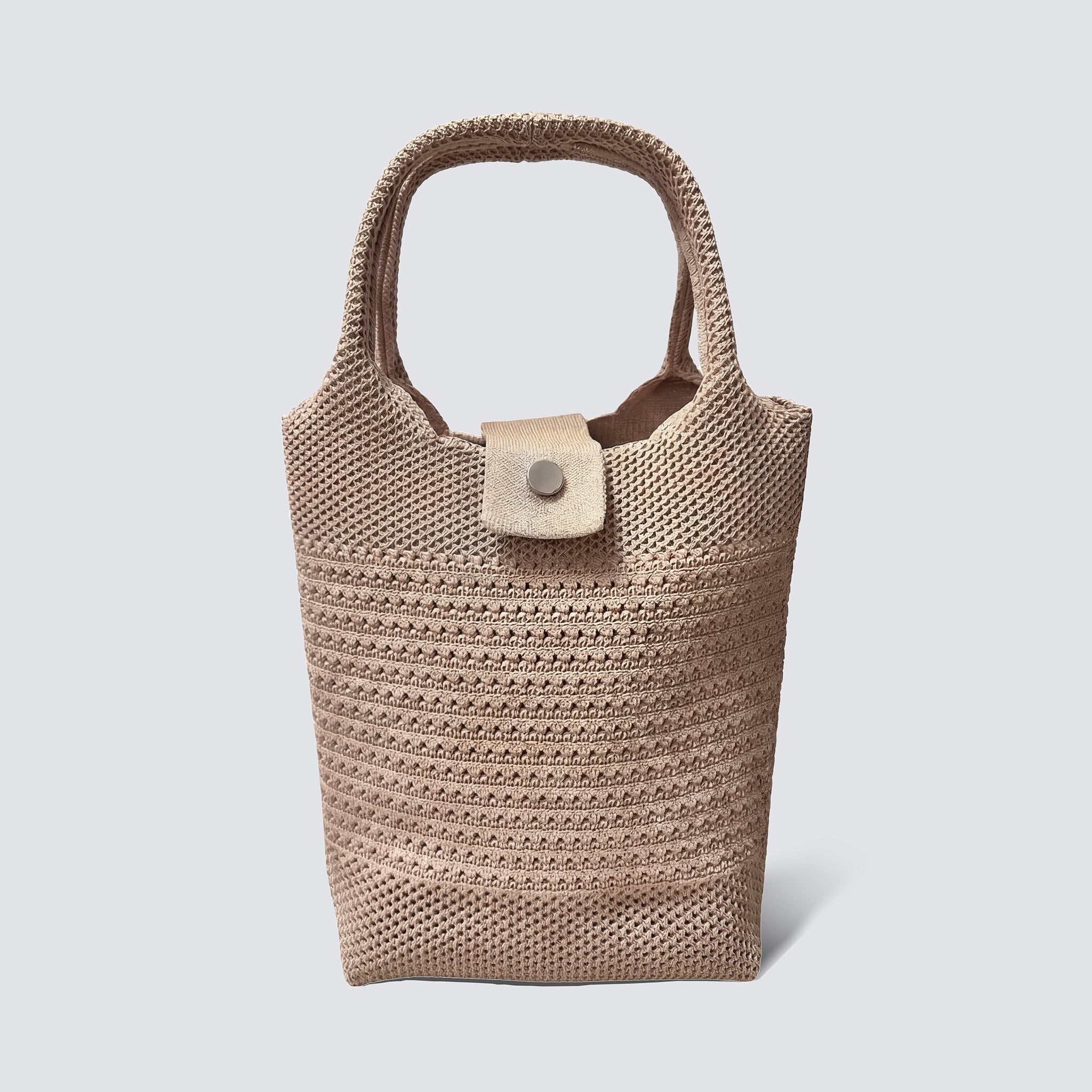 Natural woven mini beach tote bag with top handles on a simple product background