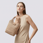Natural woven mini beach tote bag carried by hand with a neutral summer look