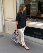 Woman carrying The Nomad geometric canvas tote bag on a city street