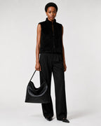 Model carrying The Onyx black woven vegan leather tote bag by hand at her side