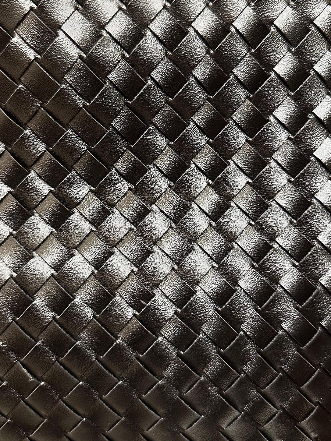 Close-up of the wide woven vegan leather texture on The Onyx black shoulder bag