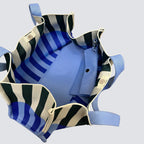 Close-up detail of an oversized blue and green striped knit tote bag