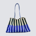 Oversized blue and green striped knit tote bag on a simple product background