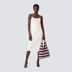 Pink and navy blue striped knit beach bag worn over the shoulder