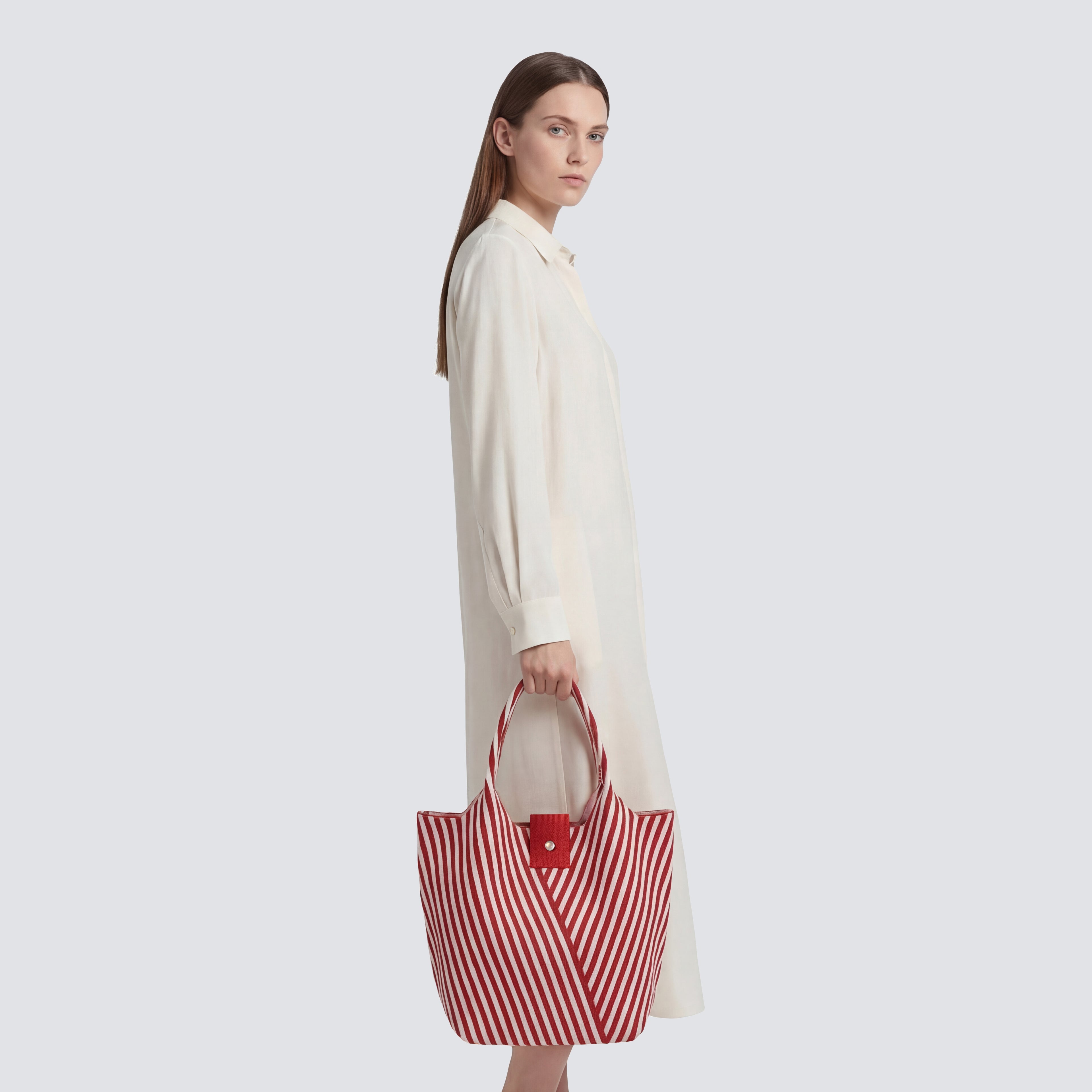 Woman carrying a red and white striped knit summer tote bag with a casual outfit
