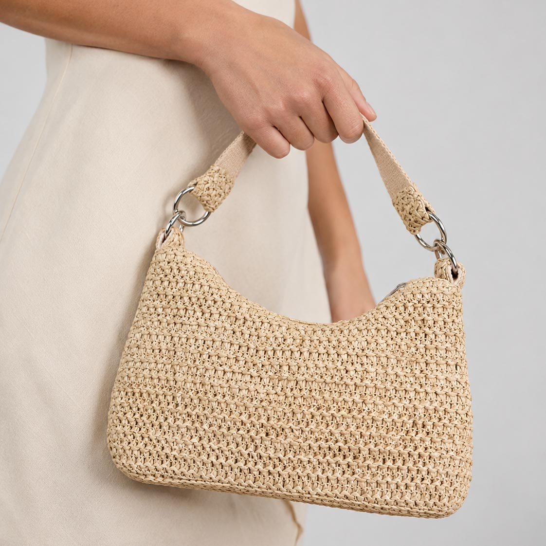 Woman carrying The Riviera convertible woven straw bag with short strap