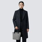 Woman carrying a textured black and white knit tote bag with a minimalist everyday outfit
