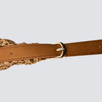Close-up of the brown vegan leather adjustable shoulder strap with a gold buckle