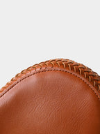 Close-up detail of the precise artisan stitching connecting the solid vegan leather base to the chunky knit body of the brown tote bag.