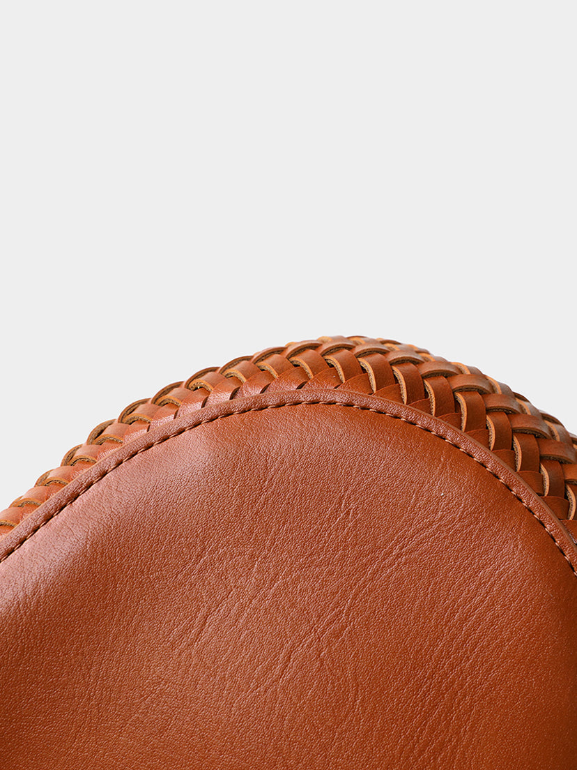 Close-up detail of the precise artisan stitching connecting the solid vegan leather base to the chunky knit body of the brown tote bag.