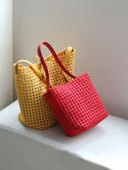 Two vibrant genuine leather lattice woven tote bags in mustard yellow and bright red.