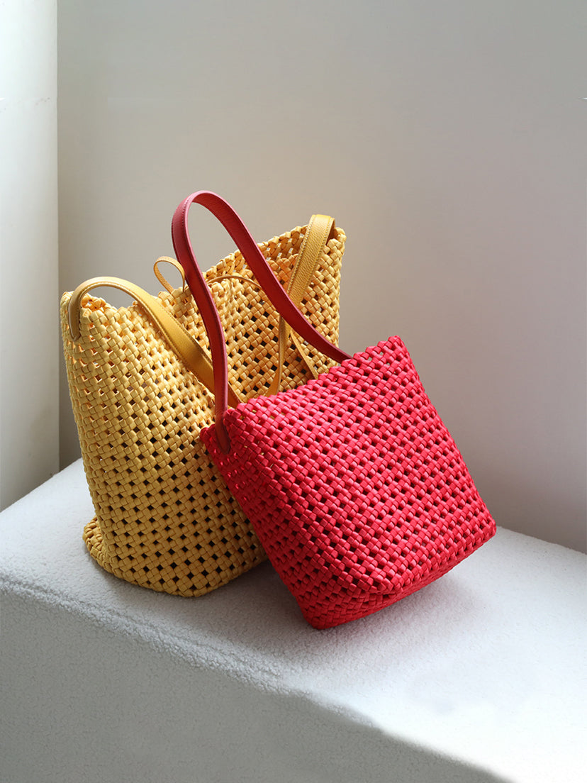 Two vibrant genuine leather lattice woven tote bags in mustard yellow and bright red.