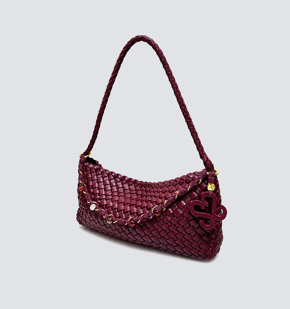 Angled view of the structured woven commuter bag in deep burgundy vegan leather