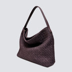 Angled view of the dark plum woven hobo commuter bag