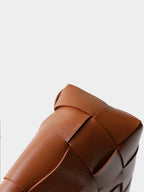 Detailed view of the seamless artisan edge crafting and wide shoulder strap integration on the genuine leather handbag.