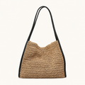 Front view of a natural woven paper straw beach tote bag with black vegan leather trims