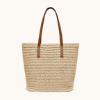 Front view of a light beige woven paper straw tote bag with brown vegan leather straps