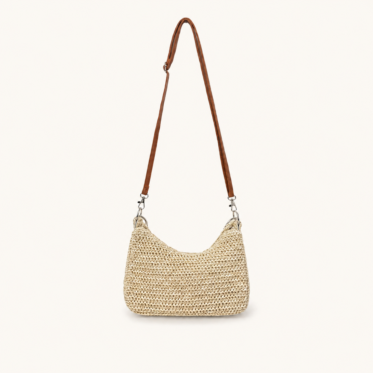 Front view of a natural woven paper straw crossbody beach bag with a long brown strap