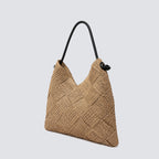 Angled view of the slouchy woven straw summer hobo bag