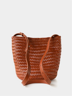 Detailed view of the sturdy adjustable strap and metal hardware on the brown handwoven vegan leather tote bag.