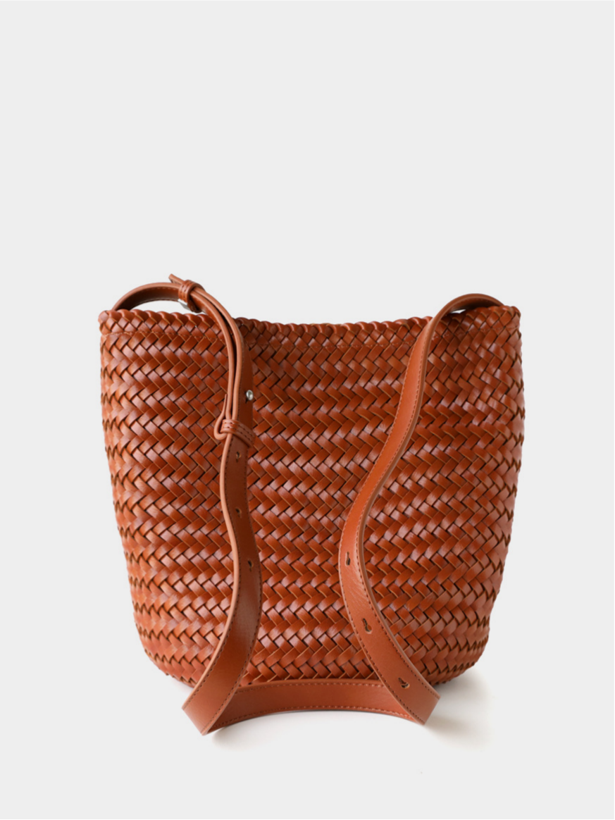 Detailed view of the sturdy adjustable strap and metal hardware on the brown handwoven vegan leather tote bag.