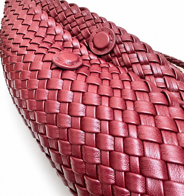 Close-up of the hidden magnetic button closure on the burgundy woven bag