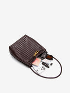 Woven vegan leather bucket bag shown with phone sunglasses makeup and daily essentials