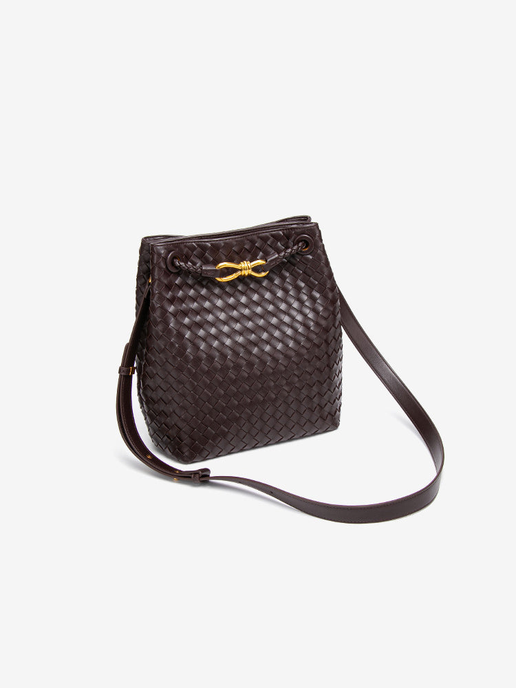 Angled view of chocolate brown woven vegan leather bucket bag with long crossbody strap