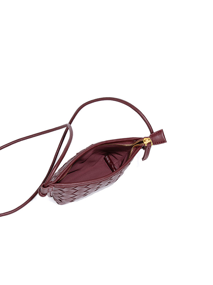 Interior view of the burgundy woven crossbody bag showing the secure zipper closure and premium soft fabric lining.