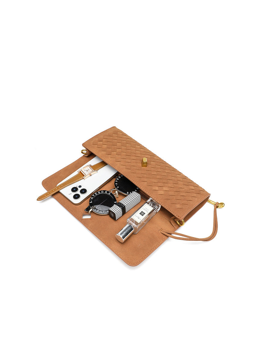 Open view of the woven vegan leather flap bag showcasing its practical capacity for a phone, sunglasses, perfume, and daily essentials.