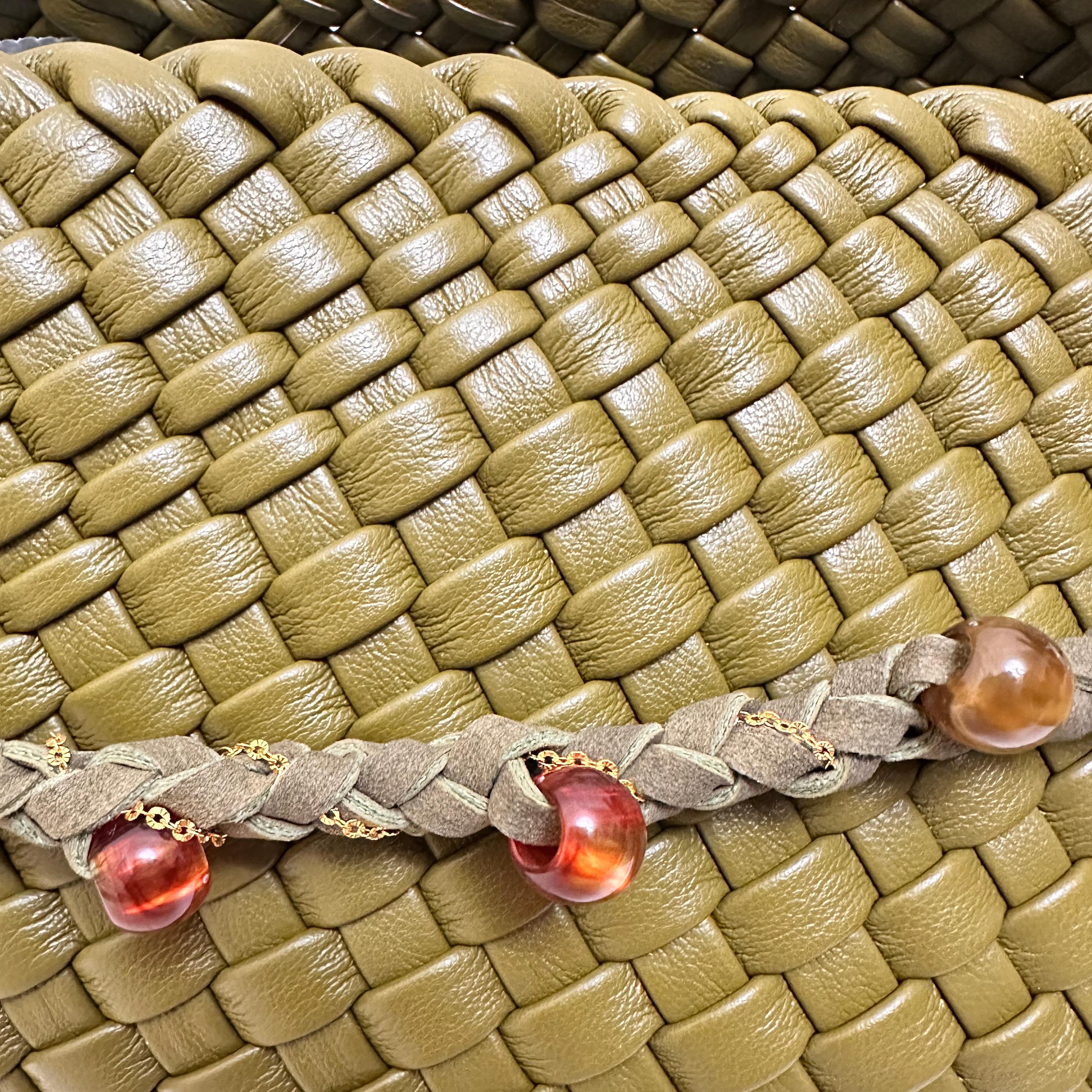 Macro detail of the green woven vegan leather pattern and the decorative braided strap with amber beads