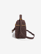 Side view of chocolate brown woven vegan leather crossbody bag with adjustable detachable strap