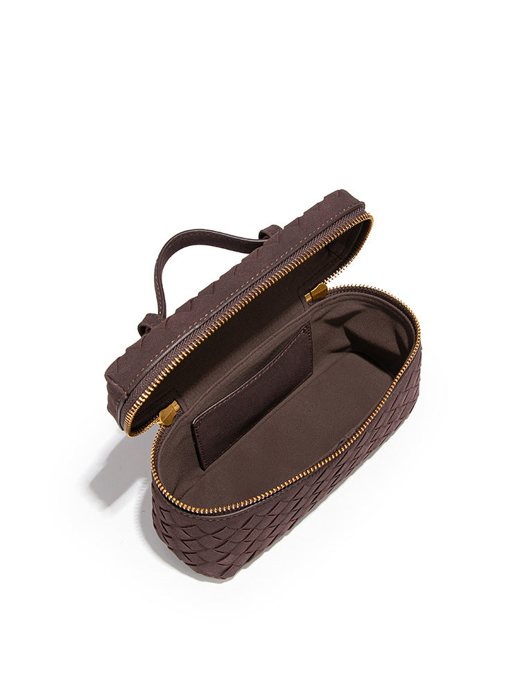 Open woven vegan leather crossbody bag showing zip closure main compartment and interior slip pocket