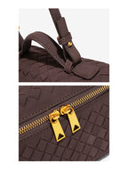 Close-up of adjustable strap hardware and gold double zipper on woven vegan leather crossbody bag